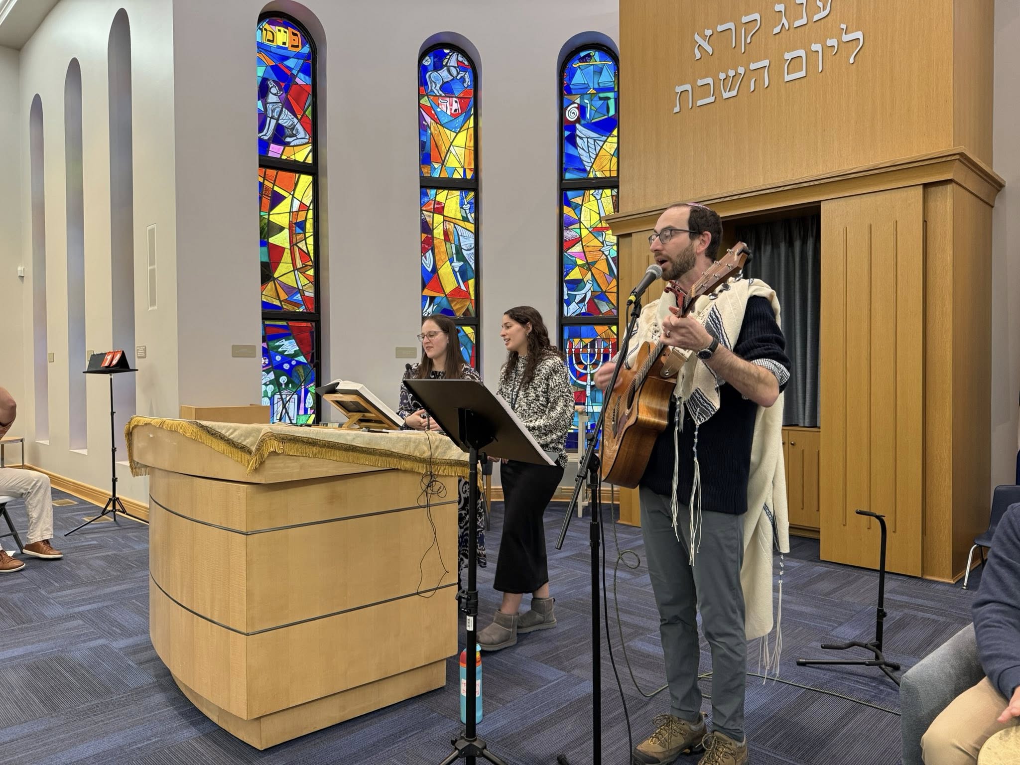 Rabbi Josh with a guitar on the Bima